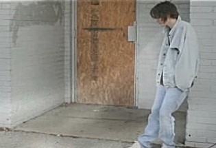 Image from vignette: Victim standing in front of building.